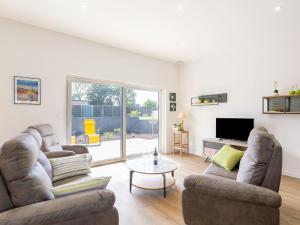 a living room with two couches and a tv at Holiday Home Les Bruyères by Interhome in Tréflez