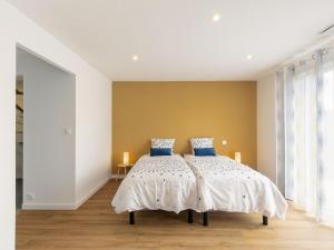 a bedroom with a bed with two blue pillows at Holiday Home Les Bruyères by Interhome in Tréflez