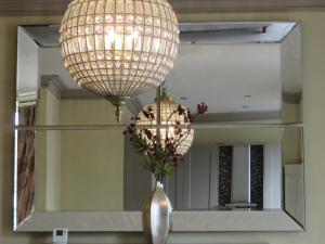 a mirror with a vase with a flower in it at Hewlett Apartments in Cheltenham