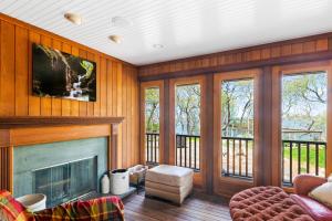 una sala de estar con chimenea y paredes de madera. en Fort Pond Paradise, en Montauk