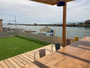 a deck of a boat with a table and grass at Mon P'tit Hôtel in Le Grau-dʼAgde