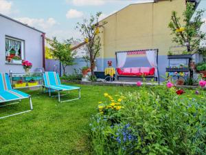 une cour avec deux chaises, un banc et des fleurs dans l'établissement Apartment Gloggnitz by Interhome, à Gloggnitz