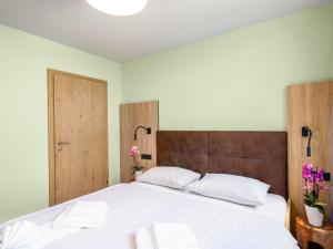 a bedroom with a large white bed with two pillows at Apartment Sunny by Interhome in Zell am See