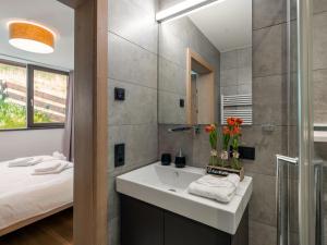 a bathroom with a sink and a mirror and a bed at Apartment Sunny by Interhome in Zell am See