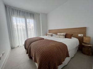 a bedroom with two beds and a large window at Mesas Homes luxury 4 bed apartment near the sea and port Estepona in Estepona +17 photos