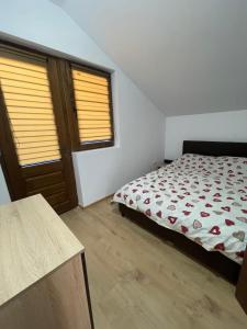 a bedroom with a bed and two windows at Cabana Retegan Băile Figa in Beclean