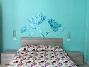 a bedroom with a bed with flowers on the wall at Casa dello Yoga Suite e Private Spa in Colonnella