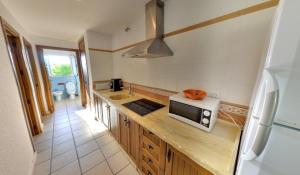 a kitchen with a counter top with a microwave at Apartamentos Costa Trafalgar in Zahora +19 photos