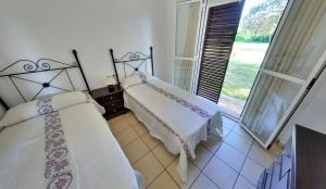 2 camas en una habitación con ventana en Apartamentos Costa Trafalgar, en Zahora