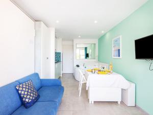 un salon avec un canapé bleu et une table dans l'établissement Studio L'Esquinade P1 101 by Interhome, à Agay