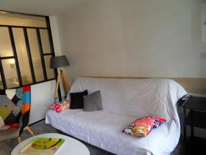 - un canapé blanc avec des oreillers dans l'établissement Le studio d' EMI, à Argelès-Gazost