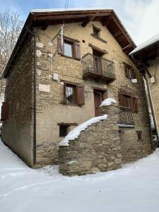 a stone building with snow on the side of it at CASA TON, junto a Baqueira y Aigüestortes in Sorpe