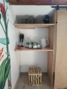 a shelf with cups and other items on it at La ferme des Escampades in Monteux