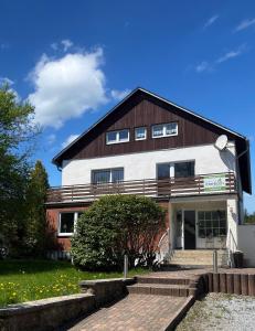 a large white building with a wooden roof at Landhaus am Itterbach Willingen in Willingen