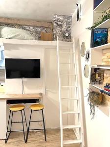 un letto a soppalco con scrivania e 2 sgabelli. di Loft Augustins a Parigi