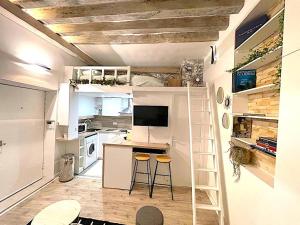 een kleine keuken met een bureau en 2 krukken bij Loft Augustins in Parijs