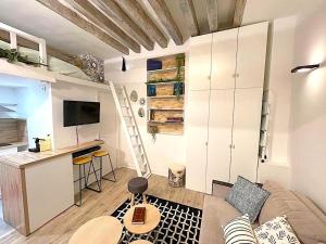 een kleine woonkamer met een bank en een keuken bij Loft Augustins in Parijs