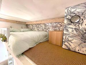 een slaapkamer met een groot bed met een muur bij Loft Augustins in Parijs