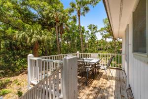a porch with a table and chairs on a deck at Geechee Girl in Edisto Beach +24 photos