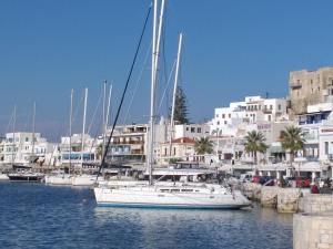 a white boat docked in a harbor with buildings at Yacht Marine Maison in Naxos Chora