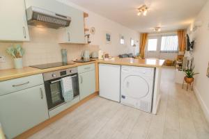 a kitchen with a washer and dryer in it at Driftwood in Marazion
