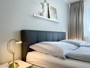 a bed with a blue headboard in a bedroom at M5 Bungalow - Apartmenthaus Marienburger Str 4 - FERIENDOMIZIL HOLLICH in Grömitz