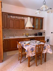 una cucina con tavolo, sedie e lavandino di Holiday mode EVA a Partinico