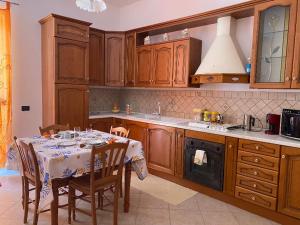 a kitchen with a table with chairs and a stove at Holiday mode EVA in Partinico