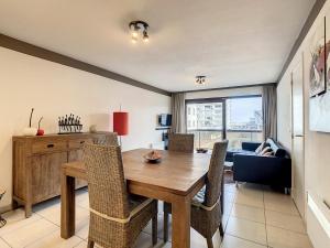 een eetkamer met een houten tafel en stoelen bij Appartement 'Plaza' te Oostduinkerke - Bad in Oostduinkerke-Bad