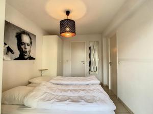 een slaapkamer met een groot wit bed. bij Appartement 'Plaza' te Oostduinkerke - Bad in Oostduinkerke-Bad