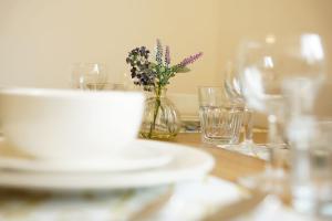 een tafel met borden en een vaas met bloemen erin bij 10BH Dreams Unlimited- Budget Heathrow Long stay Apartment with FREE PARKING in Ashford +16 foto's
