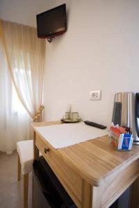 a room with a desk with a television on the wall at Villa Cristina in Monterosso al Mare