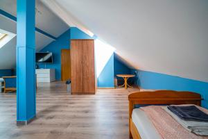 sypialnia z łóżkiem i niebieską ścianą w obiekcie Pod Niebem Jurata w Juracie