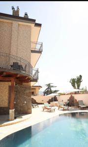 uma piscina num resort com cadeiras e um edifício em Villa Elisabetta em Pompeia