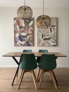 a dining room table with four green chairs at Cordoba Luxury Home in Córdoba