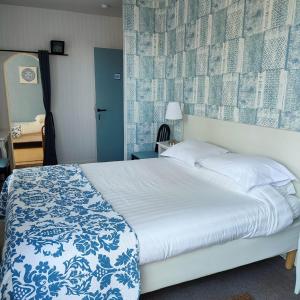 a bedroom with a bed with a blue and white blanket at Les Chenes Chambres D'hote in Châtel-Guyon