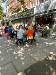 un grupo de personas sentadas en las mesas fuera de un restaurante en Lily, en Whetstone