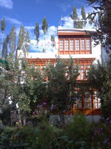 a building with a lot of windows and trees at Thangkop House in Leh