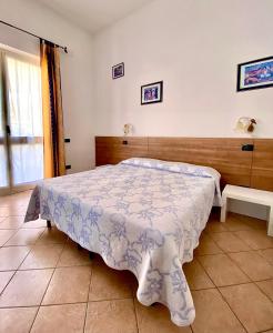 Schlafzimmer mit einem Bett mit einer blauen und weißen Bettdecke in der Unterkunft Locanda Da Marco in Pignone