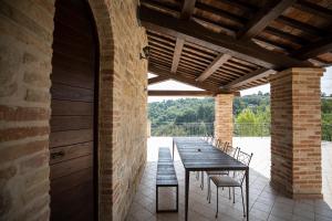 an outdoor patio with a wooden table and chairs at Villa Ermelinda - Matrimoni, piscina e jacuzzi in Castelraimondo +29 photos