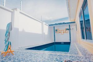 einen Pool in einem Haus mit blauen Bodenfliesen in der Unterkunft Heavenly ApHEARTment with backyard swimming pool in Dodoma