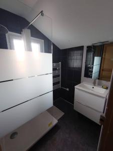 a white bathroom with a sink and a mirror at Maison entre Plages et Forêts in Lévignacq