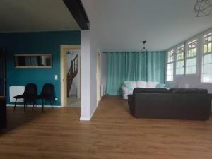 a living room with a couch and blue walls at Maison entre Plages et Forêts in Lévignacq