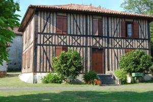 a house with a brown door in a yard at Maison entre Plages et Forêts in Lévignacq