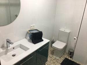 łazienka z umywalką, toaletą i lustrem w obiekcie Casa Collado w mieście San Vicente