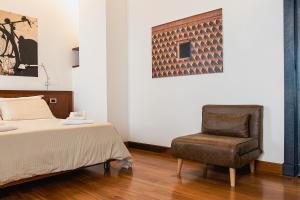 1 dormitorio con 1 cama y 1 silla en Boutique Rooms 3 0, en Ferrara