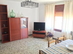 a living room with a tv and a dresser with a televisionicter at Casa Collado in San Vicente