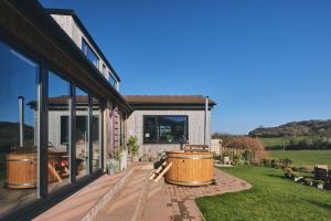 a house with a large tub on a patio at Benllech Beach House in Benllech