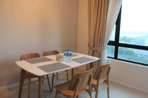 d'une salle à manger avec une table, des chaises et une fenêtre. dans l'établissement Suasana Suites D'Home JB, à Johor Bahru