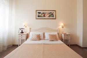 Un dormitorio con una cama grande con dos mesitas de noche. en il Castello Guest House, en Sassari